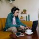 Фрийлансър работи на лаптоп от домашен офис