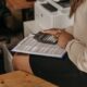 Жена преглежда финансови документи с калкулатор в офис