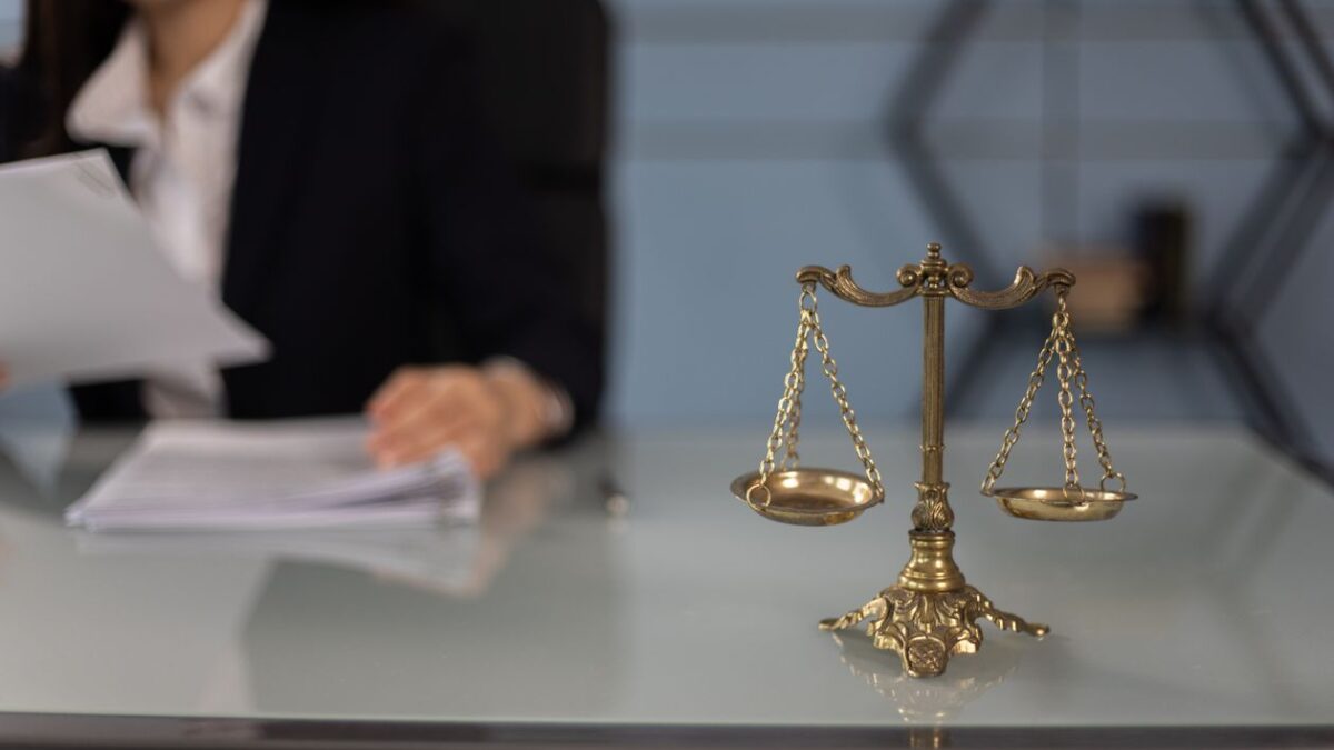 Везни на правосъдието върху бюро с документи