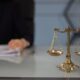 Везни на правосъдието върху бюро с документи