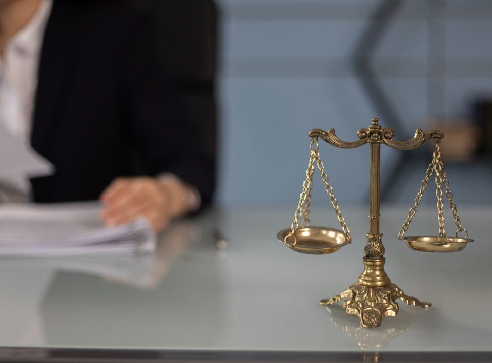 Везни на правосъдието върху бюро с документи